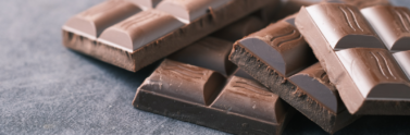 Unwrapped milk chocolate bars on black table