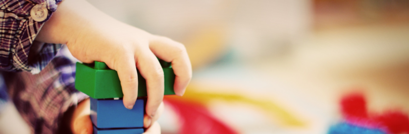 child building a tower of lego