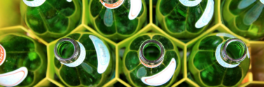 the top of empty glass bottles in a yellow container